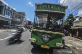 Wisatawan menaiki bus Ngulisik atau Bus wisata perkotaan saat melintasi di Jalan Kota Tasikmalaya, Jawa Barat, Minggu (7/4/2019). Pemerintah Provinsi Jabar bekerjasama dengan Bank Bjb meluncurkan Bus Wisata Perkotaan kepada 13 kabupaten dan kota yang mempunyai potensi dan keragaman wisata dan penyediaan Bus Wisata Perkotaan dalam rangka meningkatkan pelayanan kepada masyarakat baik lokal maupun asing dalam mengakses destinasi wisata yang ada di wilayah masing-masing dengan nyaman, berkeselamatan, dan terjangkau. ANTARA JABAR/Adeng Bustomi/agr