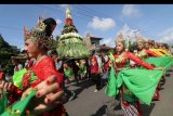 Warga membawa gunungan berisi hasil bumi saat kirab budaya di Desa Dukuh, Kediri, Jawa Timur, Minggu (7/4/2019). Kegiatan yang diikuti warga setempat itu bertujuan mempromosikan desa Dukuh sebagai desa wisata dengan destinasi andalannya berupa sumber air Sugih Waras. ANTARA FOTO/Prasetia Fauzani/nym