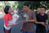 Polisi wanita membagikan poster imbauan terkait keamanan dan ketertiban masyarakat (Kamtibmas) menjelang Pemilu kepada warga saat hari bebas kendaraan di Denpasar, Bali, Minggu (7/4/2019). Kegiatan tersebut sekaligus untuk mengimbau warga agar menggunakan hak suaranya pada Pemilu 2019 yang digelar 17 April mendatang. ANTARA FOTO/Nyoman Hendra Wibowo/nym