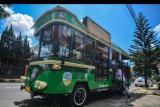 Wisatawan menaiki bus Ngulisik atau bus wisata perkotaan saat melintasi di Jalan Kota Tasikmalaya, Jawa Barat, Minggu (7/4/2019). Bus Wisata Perkotaan tersebut diluncurkan bagi 13 kabupaten dan kota yang mempunyai potensi dan keragaman wisata. ANTARA FOTO/Adeng Bustomi/nym