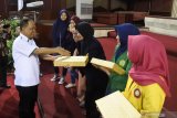 Menteri Riset, Teknologi, dan Pendidikan Tinggi (Menristekdikti) Mohammad Nasir (kiri) menyerahkan laptop kepada mahasiswa berprestasi usai kuliah umum di Universitas Jember, Jawa Timur, Minggu (7/4/2019).  Menristekdikti mengatakan bahwa kenaikan kuota penerima beasiswa Bidikmisi tahun 2019 sebanyak 130.000 orang, naik dibanding tahun 2018 yang mencapai 90.000 orang penerima. Antara Jatim/Seno/zk.