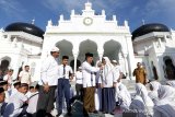 Wali Kota Banda Aceh Aminullah Usman (tengah) berdialog dengan pelajar Sekolah Menengah Pertama (SMP) saat mengikuti doa bersama jelang Ujian Sekolah Berstandar Nasional (USBN) dan Ujian Nasional (UN) di Masjid Raya Baiturrahman, Banda Aceh, Senin (8/4/2019). Doa bersama dan zikir yang diikuti para pelajar dari seluruh SMP di kota Banda Aceh itu untuk menguatkan mental dan spiritual  siswa dalam menghadapi USBN dan UN tahun pelajaran 2018/2019 serta mampu meraih nilai yang memuaskan. (Antara Aceh/Irwansyah Putra)