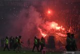 Sejumlah petugas keamanan berjaga-jaga ketika suporter Persebaya Surabaya menyalakan 'flare'  dan melempar botol minuman saat akhir laga final leg 1 Piala Presiden 2019 antara Persebaya Surabya lawan Arema FC di Gelora Bung Tomo, Surabaya, Jawa Timur, Selasa (9/4/2019). Pertandingan tersebut berakhir imbang dengan skor 2-2. Antara Jatim/Zabur Karuru.