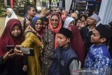 Menteri Kelautan dan Perikanan Susi Pudjiastuti berswafoto dengan warga pada kunjungan kerja di Pondok Pesatren An Nur Jarnauziyah, Kota Tasikmalaya, Jawa Barat, Rabu (10/4/2019). Dalam kunjungannya Menteri Susi, mengatakan Pemerintah telah menenggelamkan 488 kapal pencuri ikan yang ditangkap di perairan laut Indonesia, selain itu memberikan bantuan 12 lubang paket budidaya nila bioflok dan benih ikan nila, satu ton pakan mandiri, serta satu ton ikan laut. ANTARA JABAR/Adeng Bustomi/agr