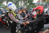 Petugas Dinas Perhubungan Kota Surabaya dan polisi memberikan himbauan kepada pengendara motor yang kedapatan merokok saat berkendara motor disela sosialisasi pelarangan merokok saat berkendara di Jalan Darmo, Surabaya, Jawa Timur, Selasa (9/4/2019). Kegiatan itu untuk mensosialisasikan Peraturan Menteri Perhubungan Nomor PM 12 Tahun 2019 terkait  pelarangan merokok dan menggunakan telepon selular saat berkendara, baik roda empat atau roda dua. Antara Jatim/Didik Suhartono/zk