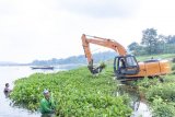 Petugas mengoperasikan alat berat saat membersihkan tanaman eceng gondok di perairan Waduk Jatiluhur, Pelabuhan Biru, Purwakarta, Jawa Barat, Rabu (10/4/2019). Menurut Direktur Utama Perum Jasa Tirta II U. Saefudin Noer pengelolaan dan pemeliharaan waduk merupakan upaya melindungi dan melestarikan sumber air untuk ketahanan air nasional yang berkesinambungan bagi kehidupan masyarakat. (ANTARA FOTO)