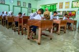 Sejumlah siswa SD kelas VI mengikuti ujian sekolah di ruang kelas yang terendam banjir di SD Negeri Sayung 4, Sayung, Demak , Jawa Tengah, Rabu (10/9/2019). Aktivitas ujian sekolah terganggu karena banjir yang merendam sekolah tersebut setinggi sekitar 15-30 sentimeter akibat luapan Sungai Dombo-Sayung karena tidak mampu menampung debit air kiriman dari hulu atau wilayah Kabupaten Semarang. ANTARA FOTO/Aji Styawan/nym.