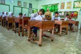 Sejumlah siswa SD kelas VI mengikuti ujian sekolah di ruang kelas yang terendam banjir di SD Negeri Sayung 4, Sayung, Demak , Jawa Tengah, Rabu (10/9/2019). Aktivitas ujian sekolah terganggu karena banjir yang merendam sekolah tersebut setinggi sekitar 15-30 sentimeter akibat luapan Sungai Dombo-Sayung karena tidak mampu menampung debit air kiriman dari hulu atau wilayah Kabupaten Semarang. ANTARA FOTO/Aji Styawan/hp.