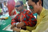 Warga penyandang disabilitas meraba surat suara saat sosialisasi pendidikan pemilih basis disabilitas di balai desa kawasan Krian, Sidoarjo, Jawa Timur, Sabtu (13/4/2019). Kegiatan gelaran Komisi Pemilihan Umum (KPU) setempat yang diikuti  puluhan warga penyandang Disabilitas tersebut bertujuan untuk memberikan pemahaman tahap-tahap pilkada serta menekan angka golput bagi penyandang disabilitas. Antara Jatim/Umarul Faruq/zk.