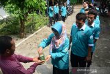 Siswa memasukkan uang ke dalam kotak infak sebelum melangsungkan UNBK paket C hari kedua di Pusat Kegiatan Belajar Masyarakat (PKBM) Sanggar Belajar Yalatif Dusun Babatan, Kecamatan Diwek, Jombang, Jawa Timur, Sabtu (13/4/2019). PKBM Sanggar Belajar Yalatif memperkuat pendidikan karakter kepada para siswanya untuk menanamkan jiwa sosial terhadap sesama yang membutuhkan serta kemauan menyisihkan sebagian rezeki agar diberi kelancaran dalam mengerjakan soal UNBK. Antara Jatim/Syaiful Arif/zk.