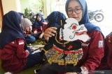 Mahasiswa menyelesaikan pembuatan wayang kulit berbahan karton saat mengikuti praktik kewirausahaan di tempat kerajinan wayang kulit di Kota Madiun, Jawa Timur, Sabtu (13/4/2019). Puluhan mahasiswa dari sebuah perguruan tinggi negeri yang tergabung dalam Unit Kegiatan Mahasiswa (UKM) Kewirausahaan mengikuti kegiatan praktik mebuat wayang guna menambah wawawasan tentang kewirausahaa. Antara Jatim/Siswowidodo/zk.