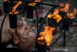 Muhammad Arsyad (79) melakukan atraksi api di Menara Pandang, Banjarmasin, Kalimantan Selatan, Senin (15/4/2019). Muhammad Arsyad yang merupakan mantan atlet lari tersebut telah menjalani atraksi api selama 15 tahun dengan memanfaatkan kekebalan tubuhnya terhadap api. Foto Antaranews Kalsel/Raisan Al Farisi.