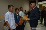 Plt Gubernur Aceh Nova Iriansyah (kanan) memberikan bingkisan kepada nelayan Aceh saat tiba di Bandara Internasional Sultan Iskandar Muda, Aceh Besar, Senin (15/4/2019). Kedutaan Besar Indonesia di Myanmar memulangkan sebanyak 22 nelayan Aceh yang ditahan di negara tesebut pada 6 Februari 2019 karena pelanggaran hukum laut, dan seorang Kapten Kapal, Fadli ditahan di Myanmar untuk menjalani proses hukum. (Antara Aceh/Ampelsa)