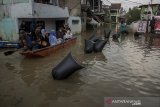 Warga menggunakan perahu untuk melihat sejumlah kesenian yang ditampilkan di area banjir pada acara Pentas Bandung Lautan Banjir di Bojongasih, Dayeuhkolot, Kabupaten Bandung, Jawa Barat, Minggu (14//4/2019). Kegiatan tersebut merupakan bentuk protes dari warga serta menjadi kegiatan untuk menghibur warga yang telah terdampak banjir sejak hampir sebulan lalu akibat luapan sungai Citarum. ANTARA JABAR/Novrian Arbi/agr.