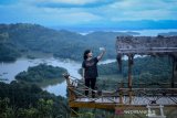 Pengunjung berswafoto dengan latar belakang Waduk Riam Kanan di wisata alam Bukit Matang Kaladan, Banjar, Kalimantan Selatan, Senin (15/4/2019). Pemerintah Provinsi Kalimantan Selatan telah menetapkan program 