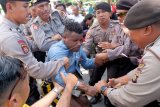 Polisi menangkap pengunjuk rasa yang melakukan aksi ajakan Golput Pemilu di Denpasar, Bali, Senin (15/4/2019). Aksi unjuk rasa tersebut dibubarkan secara paksa oleh aparat kepolisian. ANTARA FOTO/Nyoman Hendra Wibowo/nym