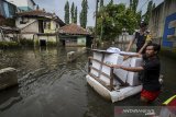 Petugas menerjang banjir dengan menggunakan perahu saat mendistribusikan logistik keperluan Pemilu dan Pileg di Desa Bojongasih, Dayeuhkolot, Kabupaten Bandung, Jawa Barat, Selasa (16/4/2019). Petugas KPU Kabupaten Bandung mendistribusikan logistik ke 11 TPS terdampak banjir dari jumlah total sebanyak 41 TPS di Kecamatan Dayeuhkolot. ANTARA JABAR/Raisan Al Farisi/agr