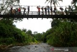 Petugas melewati jembatan gantung membawa Logistik Pemilu serentak 2019 menuju desa Atiran,kecamatan Batang Alai Timur, Hulu Sungai Tengah, Kalimantan Selatan, Selasa (16/4/2019).Sebanyak 140 kotak suara, 112 bilik suara, dan 5.292 surat suara di 11 Desa terpencil di Pegunungan Meratus Hulu Sungai Tengah telah didistribusikan KPU Kabupaten Hulu Sungai Tengah.Foto Antaranews Kalsel/Bayu Pratama S.