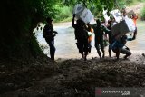 Petugas memanggul kotak suara melewati sungai menuju ke Tempat Pemungutan Suara (TPS) terpencil di Dusun Nampu, Desa Pojok Klitih, Kecamatan Plandaan, Jombang, Jawa Timur, Selasa (16/4/2019). Untuk mendistribusikan logistik pemilu 2019 ke Tempat Pemungutan Suara (TPS) 10 di dusun Nampu yang termasuk kawasan terpencil, Kelompok Penyelenggara Pemungutan Suara (KPPS) harus memutar melewati Kabupaten Nganjuk sepanjang 30 kilometer dan harus menyeberangi sungai. Antara Jatim/Syaiful Arif/zk.