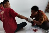 Korban penembakan kasus Pemilu 2019 Sampang Mansur (kiri) mendapat perawatan di rumah Kades Ketapang Daya, Sampang, Jawa Timur, Rabu (17/4/2019). Kasus penembakan tersebut terjadi karena saling berebut menjadi saksi pada Pemilu 2019 antara korban dengan terduga Muara di TPS 7 Dusun Tapaan Tengah, Desa Tapaan, Kecamatan Banyuates, Sampang. Antara Jatim/Rusydi Zain/sb/zk.