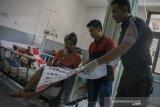 Petugas membantu pasien saat akan melakukan pemungutan suara pada pemilu 2019 di TPS 53 Rumah Sakit Umum Pemerintah Hasan Sadikin, Bandung, Jawa Barat,  Rabu (17/4/2019). ANTARA JABAR/Novrian Arbi/agr