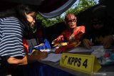 Petugas KPPS melayani warga saat akan memberikan hak suaranya di TPS 5 Pondok Benowo Indah yang bertema super hero di Surabaya, Jawa Timur, Rabu (17/4/2019). Antara Jatim/Zabur Karuru