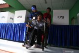 Petugas KPPS mengenakan kostum superhero Avengers membantu seorang disabilitas ketika akan memberikan hak suaranya di TPS 5 Pondok Benowo Indah yang bertema super hero di Surabaya, Jawa Timur, Rabu (17/4/2019). Antara Jatim/Zabur Karuru