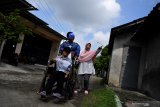 Petugas KPPS mengenakan kostum superhero Avengers membantu seorang disabilitas ketika akan memberikan hak suaranya di TPS 5 Pondok Benowo Indah yang bertema super hero di Surabaya, Jawa Timur, Rabu (17/4/2019). Antara Jatim/Zabur Karuru