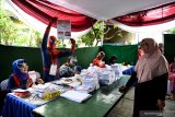 Petugas KPPS menunjukan surat suara kepada warga saat akan memberikan hak suaranya di TPS 5 Pondok Benowo Indah yang bertema super hero di Surabaya, Jawa Timur, Rabu (17/4/2019). Antara Jatim/Zabur Karuru