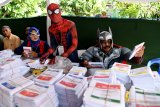 Petugas KPPS melayani warga saat akan memberikan hak suaranya di TPS 5 Pondok Benowo Indah yang bertema super hero di Surabaya, Jawa Timur, Rabu (17/4/2019). Antara Jatim/Zabur Karuru