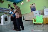 Petugas KPPS membantu warga binaan usai mencoblos di Tempat Pemungutan Suara (TPS) Lapas Klas IIB Jombang, Jawa Timur, Rabu (17/4/2019). Sebanyak 384 warga binaan Lapas setempat menggunakan hak pilihnya dalam pemilu serentak 2019. Antara Jatim/Syaiful Arif/zk