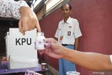 Petugas KPPS mengenakan kostum seragam SMA melakukan aktivitas di TPS 08 Kelurahan Tonatan, Kabupaten Ponorogo, Jawa Timur, Rabu (17/04/2019). Petugas mengenakan kostum tersebut dimaksudkan untuk menarik minat masyarakat guna menyukseskan Pemilu 2019. Antara Jatim/Siswowidodo/zk.