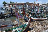 Tumpukan sampah berada di sekitar perahu nelayan yang ditambatkan di Pantai Satelit, Desa Tembokrejo, Muncar, Banyuwangi, Jawa Timur, Jumat (19/4/2019). Pemerintah mengajak semua pihak melakukan aksi pengurangan sampah plastik karena Kementerian Lingkungan Hidup dan Kehutanan RI menyebut produksi sampah plastik di Indonesia mencapai 64 juta ton/tahun dan sebagian besar mencemari lautan, seperti terlihat dari temuan LSM Greenpeace dalam sebuah aksi adanya lebih dari 700 merek sampah plastik di laut. Antara Jatim/Seno/ZK