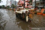 Warga melintasi banjir di kawasan jalan Lambung Mangkurat, Banjarmasin, Kalimantan Selatan, Sabtu (20/4/2019).Banjir yang merendam jalan Kota tersebut masih menjadi masalah rutin yang belum bisa diselesaikan Pemerintah Kota Banjarmasin saat tingginya intensitas curah hujan ditambah tata kelola drainase yang buruk dan masih rendahnya kesadaran masyarakat untuk tidak membuang sampah sembarangan. Foto Antaranews Kalsel/Bayu Pratama S.