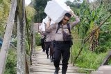 DISTRIBUSI LOGISTIK PEMILU DI PERBATASAN. Sejumlah anggota kepolisian memanggul logistik Pemilu serentak 2019 melintasi hutan menuju Dusun Buntan di Desa Bungkang, Kecamatan Sekayam, Kabupaten Sanggau, Kalimantan Barat, Selasa (16/4/2019). Sejumlah anggota TNI/Polri harus berjalan kaki memanggul logistik Pemilu untuk didistribusikan ke tiga Tempat Pemungutan Suara (TPS) di Dusun Bantan yang berbatasan langsung dengan Malaysia. ANTARA FOTO/Agus Alfian/jhwANTARA FOTO/AGUS ALFIAN (ANTARA FOTO/AGUS ALFIAN)