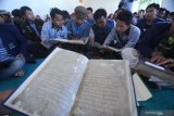 Mahasiswa IAIN Jember mengamati kitab kuno saat 