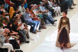 Model memperagakan busana disela-sela jumpa pers 'Parade 101 Kebaya Millennial' di Surabaya,  Jawa Timur, Sabtu (20/4/2019). Peragaan busana itu digelar untuk memperingati Hari Kartini. Antara Jatim/Didik Suhartono/zk.