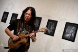  Seniman DOddy Hernanto yang akrab dipanggil Mr D bermain gitar dengan latar lukisan sketsa hasil karyanya yang di pamerkan pada lukisan digital yang bertema 'Putih di atas hitam' di Visma Art Gallery', Surabaya, Jawa Timur, Senin (22/4/2019). Pameran tersebut memadukan sketsa dengan digital yakni dengan memindai lukisan itu dengan gawai dan akan tampak konten berupa animasi dan video tentang penjelasan sketsa yang dipindai. Antara Jatim/Zabur Karuru/Zk