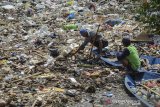 Warga mengambil sampah pascabanjir di Sungai Cikapundung yang bermuara ke Sungai Citarum di Bojongsoang, Kabupaten Bandung, Jawa Barat, Senin (22/4/2019). Warga menyatakan, banjir yang merendam ratusan pemukiman selama dua minggu akibat luapan Sungai Citarum tersebut telah surut dan menyisakan lumpur setinggi 30 hingga 60 sentimeter serta tumpukan sampah. ANTARA JABAR/Raisan Al Farisi/agr