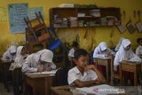 Siswa mengikuti Ujian Sekolah Berstandar Nasional (USBN) di SDN VII Dayeuhkolot yang terdampak banjir di Kabupaten Bandung, Jawa Barat, Senin (22/4/2019). Sebanyak 35 siswa mengikuti USBN pascabanjir yang melanda kawasan tersebut. ANTARA JABAR/Raisan Al Farisi/agr