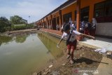 Siswa berjalan keluar kelas seusai mengikuti  Ujian Sekolah Berstandar Nasional (USBN) di SDN VII Dayeuhkolot yang terdampak banjir di Kabupaten Bandung, Jawa Barat, Senin (22/4/2019). Sebanyak 35 siswa mengikuti USBN pascabanjir yang melanda kawasan tersebut. ANTARA JABAR/Raisan Al Farisi/agr
