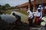 Siswa berjalan keluar kelas seusai mengikuti  Ujian Sekolah Berstandar Nasional (USBN) di SDN VII Dayeuhkolot yang terdampak banjir di Kabupaten Bandung, Jawa Barat, Senin (22/4/2019). Sebanyak 35 siswa mengikuti USBN pascabanjir yang melanda kawasan tersebut. ANTARA JABAR/Raisan Al Farisi/agr