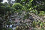 Warga menyaksikan tumpukan sampah yang menimbun makam warga di Kampung Nagrog, Kota Tasikmalaya, Jawa Barat, Selasa (23/4/2019). Akibat kurangnya kesadaran masyarakat membuang sampah pada tempatnya dan tidak adanya perhatian dari Pemerintah setempat untuk menyediakan atau memfasilitasi tempat sampah mengakibtkan puluhan makam warga tertimbun tumpukan sampah plastik sehingga menimbulkan pencemaran lingkungan. ANTARA JABAR/Adeng Bustomi/agr