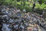 Warga menyaksikan tumpukan sampah yang menimbun makam warga di Kampung Nagrog, Kota Tasikmalaya, Jawa Barat, Selasa (23/4/2019). Akibat kurangnya kesadaran masyarakat membuang sampah pada tempatnya dan tidak adanya perhatian dari Pemerintah setempat untuk menyediakan atau memfasilitasi tempat sampah mengakibtkan puluhan makam warga tertimbun tumpukan sampah plastik sehingga menimbulkan pencemaran lingkungan. ANTARA JABAR/Adeng Bustomi/agr
