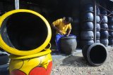 Perajin menyelesaikan proses pembuatan bak sampah dari ban bekas  di Desa Tambung, Pamekasan, Jawa Timur, Rabu (24/4/2019). Bak sampah yang dipasarkan ke sejumlah daerah itu dibandrol Rp60.000-Rp80.000 unit tergantung ukuran dan bentuk. Antara Jatim/Saiful Bahri/zk
