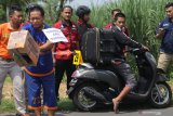 Dua tersangka pembunuhan, Aris Sugianto (kiri) membuang kardus berisi potongan kepala disaksikan Azis Prakoso yang membawa koper bersisi tubuh korban saat rekonstruksi di Kediri, Jawa Timur, Rabu (24/4/2019). Rekonstruksi kasus pembunuhan disertai mutilasi karena persoalan asmara sesama jenis tersebut memperagakan 38 reka adegan di 4 lokasi berbeda. Antara Jatim/Prasetia Fauzani/ZK