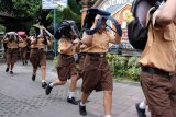 Siswa SMPN 3 Denpasar menyelamatkan diri dengan melindungi kepala menggunakan tas saat terjadi gempa dalam simulasi memperingati Hari Kesiapsiagaan Bencana di Denpasar, Bali, Jumat (26/4/2019). Kegiatan simulasi tersebut untuk melatih reaksi siswa dalam menghadapi bencana alam. ANTARA FOTO/Nyoman Hendra Wibowo/nym.