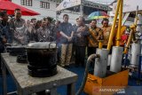 Menteri ESDM Ignasius Jonan (tengah) mendengarkan arahan saat melihat mesin produksi gas hemat energi yang dipamerkan pada acara peringatan ke-49 Hari Bumi Internasional di Museum Geologi Bandung, Jawa Barat, Sabtu (27/4/2019). Kegiatan yang bertema Harmoni Indonesia melalui Green Energy tersebut sebagai bentuk peranan Kementerian ESDM dalam sosialiasasi dan mengajak masyarakat untuk menumbuhkan kesadaran dalam menjaga dan melestarikan bumi. ANTARA JABAR/Novrian Arbi/agr