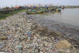 Perahu nelayan menyandarkan perahu di sekitar pantai yang tercemar sampah plastik di pelabuhan Dadap, Indramayu, Jawa Barat, Sabtu (27/4/2019). Pemerintah menargetkan pengurangan sampah plastik di laut pada hingga 70 persen pada tahun 2025. ANTARA JABAR/Dedhez Anggara/agr