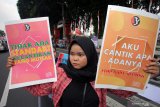 Aktivis membawa poster berisi kampanya tentang kepedulian terhadap perempuan saat menggelar aksi di Alun-alun Kota Blitar, Jawa Timur, Minggu (28/4/2019). Selain untuk mengajak masyarakat untuk lebih peduli terhadap perempuan yang sering menjadi korban kekerasan, Aksi yang digelar oleh sejumlah aktivis dari Women's March Blitar tersebut juga menuntut pemerintah untuk segera menuntaskan RUU Penghapusan Kekerasan Seksual (PKS), serta merevisi UU Perkawinan. Antara Jatim/Irfan Anshori/zk.